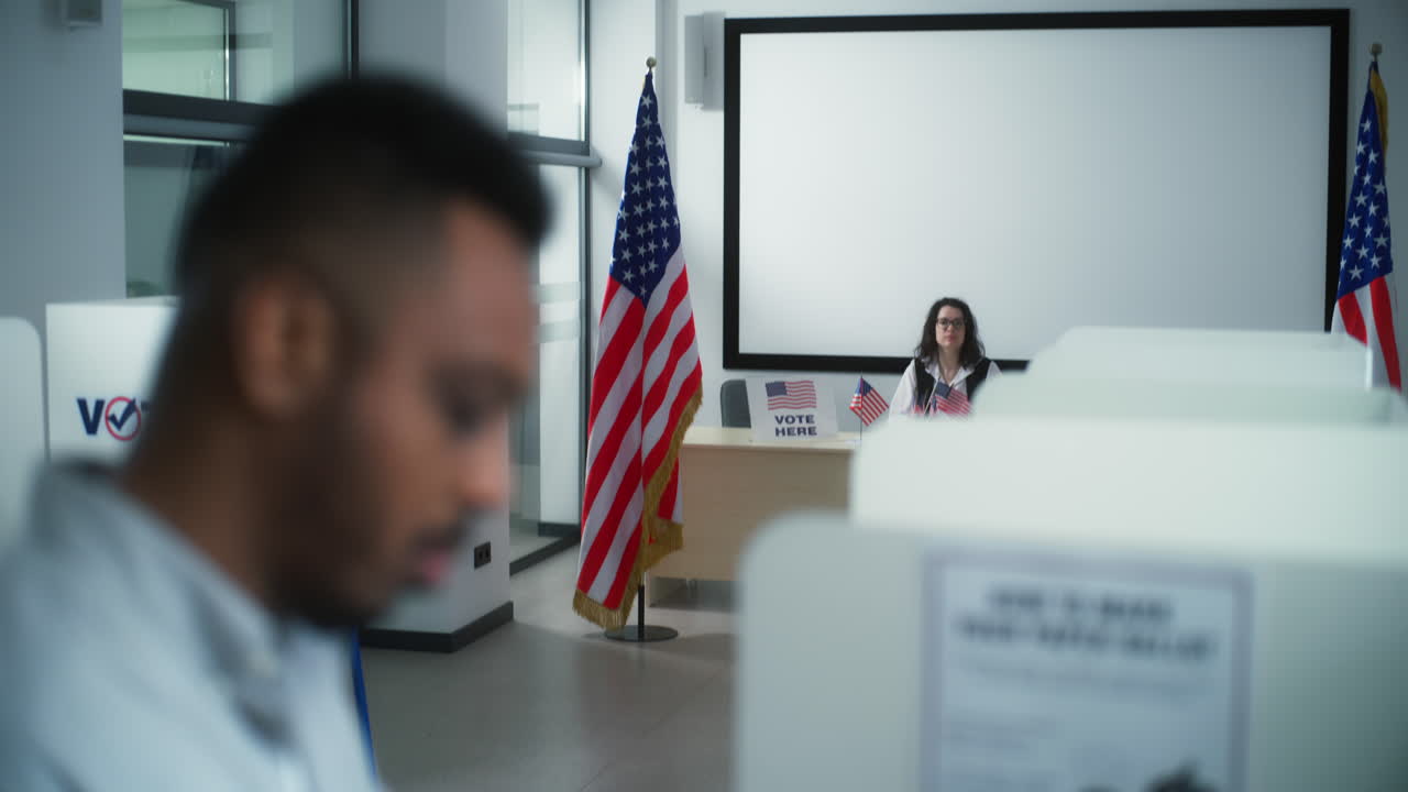 Close up of African American Male Voter in Voting Booth Close up of African American Male Voter Choosing which Presidential Candidate to Vote for in Voting Booth at Polling Station us Citizen during National Election Day in the United States Democracy