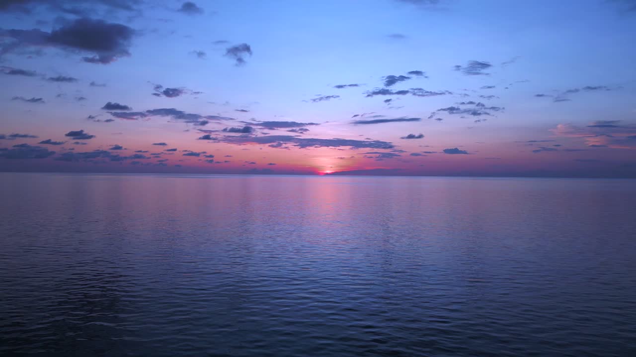 Incantevole volo aereo panoramico dall'alto: Tramonto, nuvole, sole, oceano e spiaggia, isola di Koh Chang, Thailandia 2022