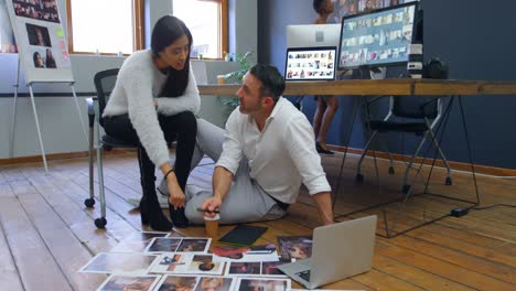 male and female graphic designers discussing over photographs 4k