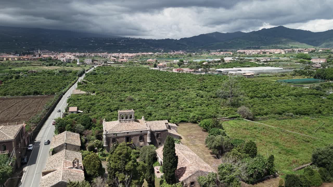 Castello degli Schiavi con vista sulla città rurale di Fiumefreddo di Sicilia, città metropolitana di Catania, Italia. Ripresa aerea orbitante