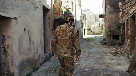 soldier checks the houses of a city devastated by bombings war