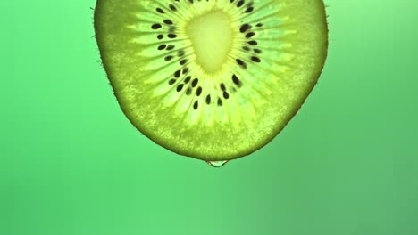 kiwi y gotas en cámara lenta.