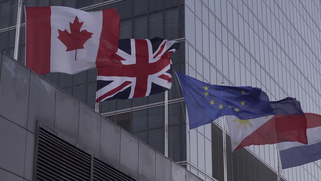 Canada, United Kingdom Union jack European Union Netherland and Philippines Flag on a windy stormy day against business center