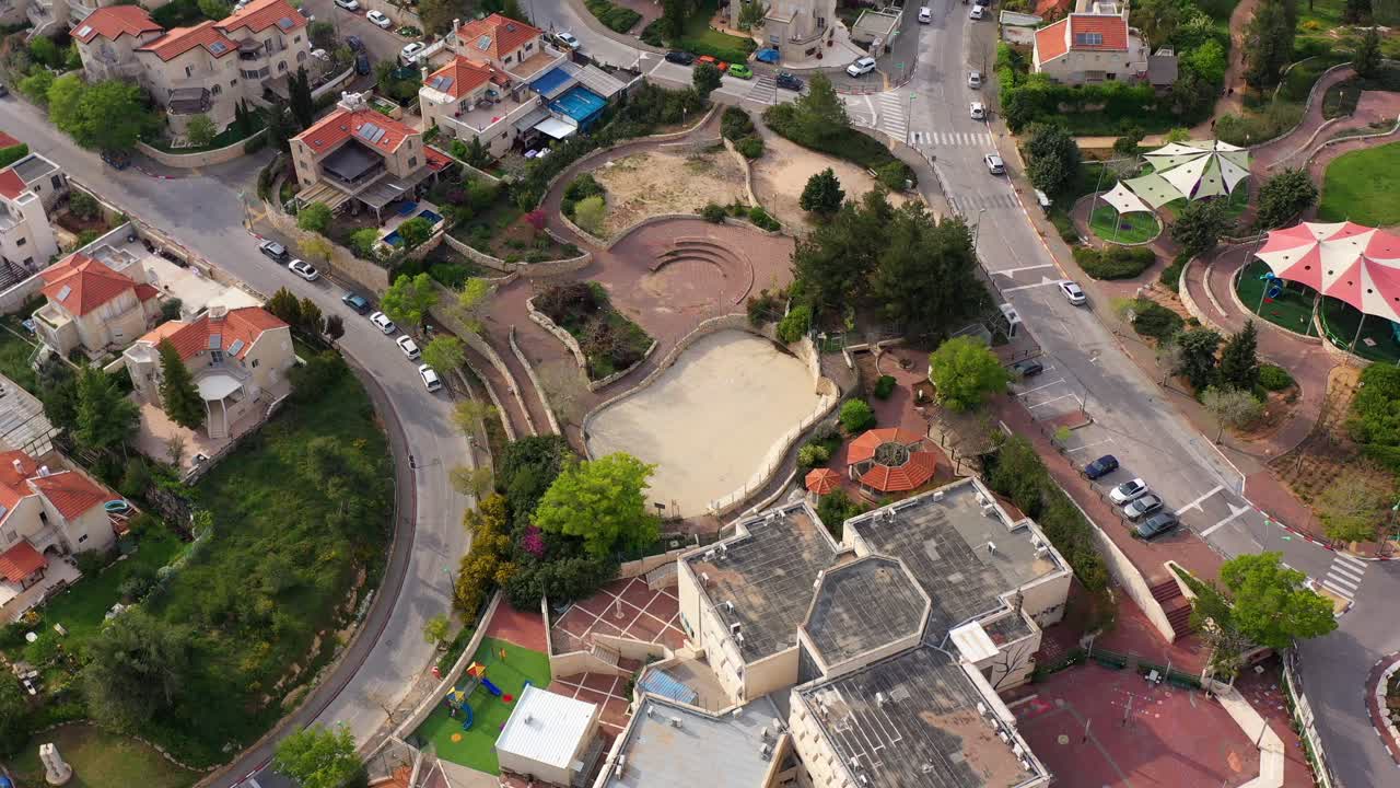Aerial view of a residential neighborhood with houses, roads, and a public park