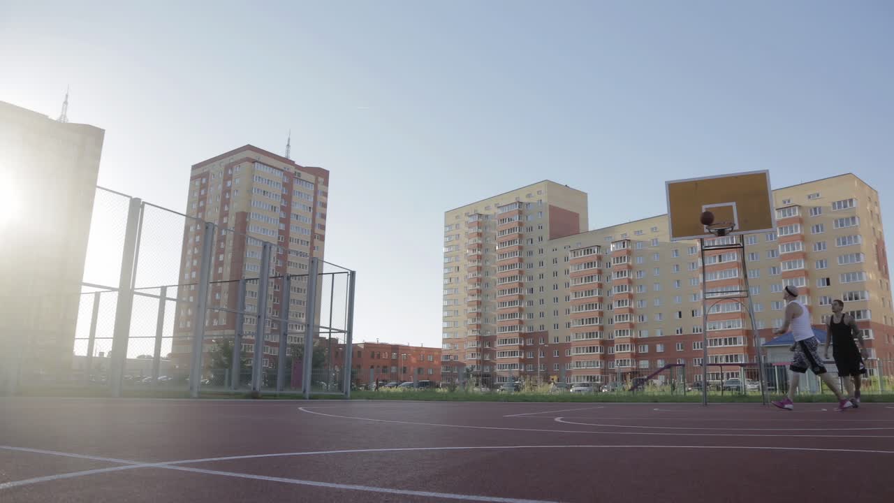 dos hombres jugando al baloncesto al aire libre