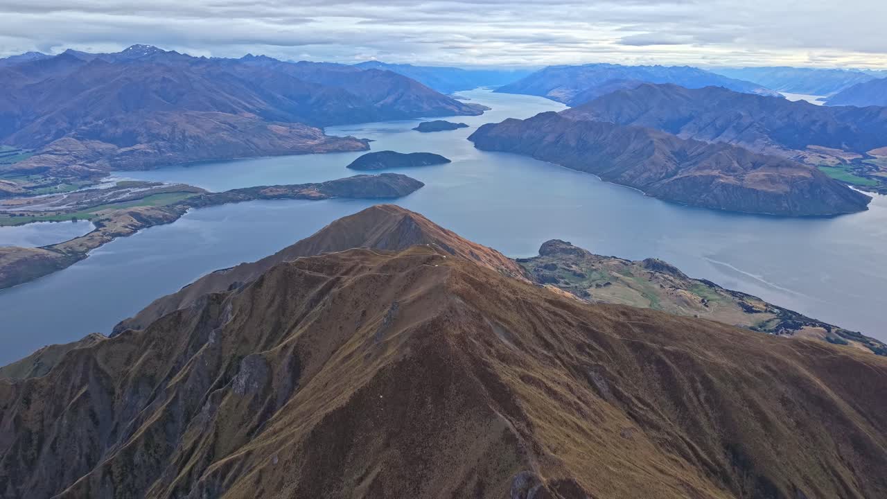 Iconic view of New Zealand's pristine natural environment, Lake Wanaka surrounded by glorious mountains filmed from Roys Peak Summit the most popular hiking track in wanaka central otago