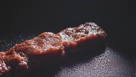 uniquely-shaped ground turkey burger patty cooking in non-stick pan