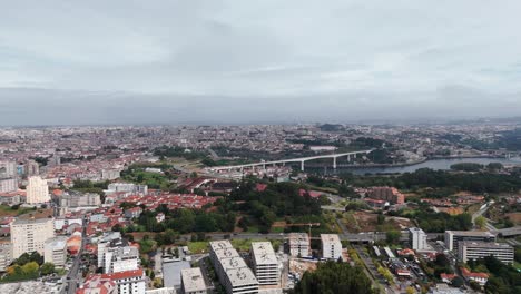 aerial view of vila nova de gaia with a bridge crossing over a river and urban buildings