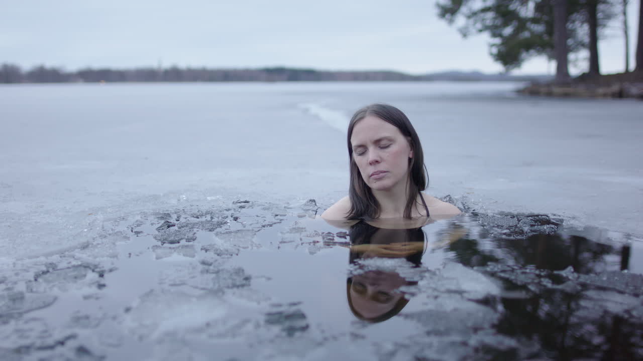 спокойный снимок красивой женщины в ледяном холодном озере в сумерках, слайдер крупного плана
