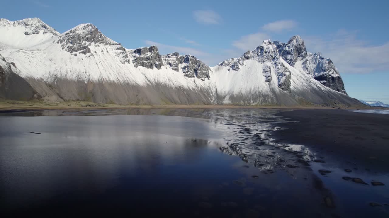 Schnee auf Berggipfeln in Stokksnes, schwarzer Strand in Südostisland.