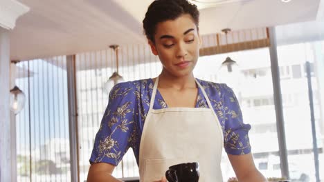 smiling waitress serving cup of coffee