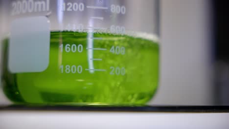 cerrar un líquido verde que se vierte para el ensayo en laboratorio