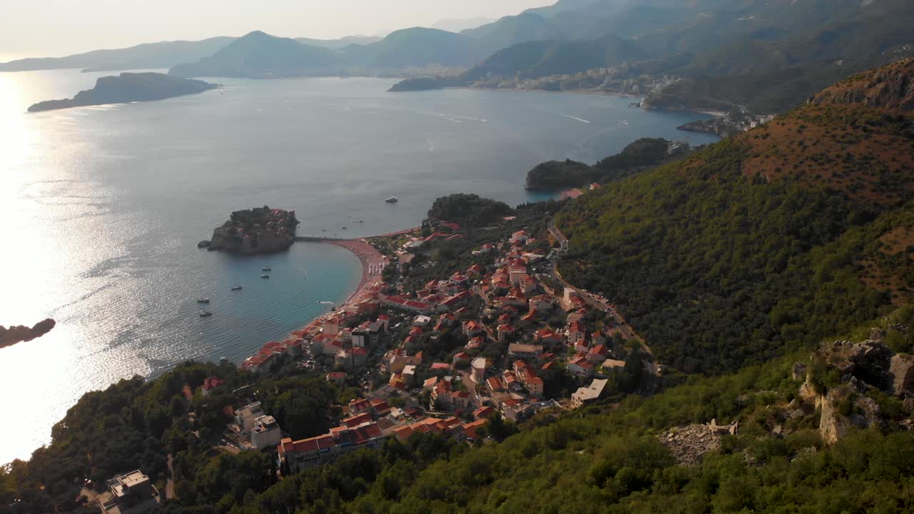 Vista Pittoresca dell'Isola di Sveti Stefan e della Piccola Città ai Piedi delle Montagne in Montenegro