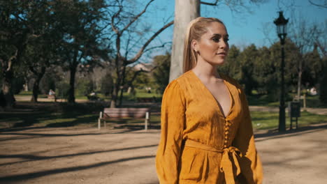 stylish young woman walking through the park.