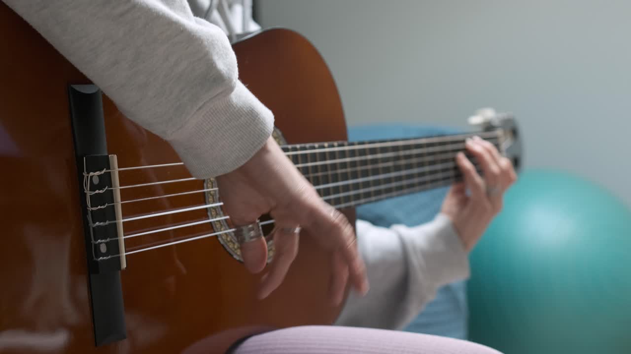 Woman playing acoustic guitar picking notes