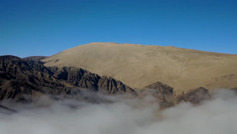 Aerial-Huge-Sand-Dune-Cerro-Blanco-Nazca-Peru-Blue-Sky-Dark-Rock-Yellow-Sand-Sea-of-Clouds-Wild-Landscape