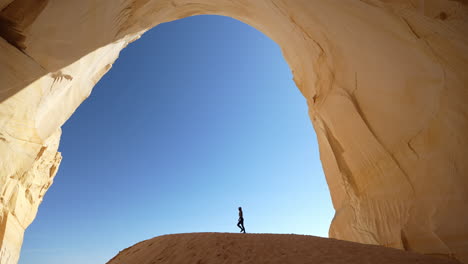 gran cámara, gran escalera escalante monumento nacional de utah estados unidos, silueta femenina caminando bajo un punto de referencia natural