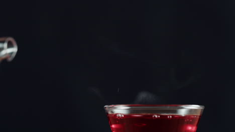 pouring hot red tea from a glass teapot