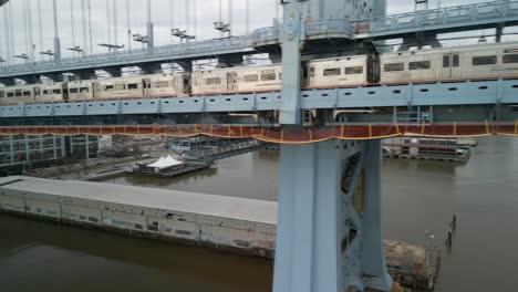 Aerial-drone-view-of-the-PATCO-Rail-line-crossing-from-Philadelphia,-Pennsylvania-to-Camden,-New-Jersey