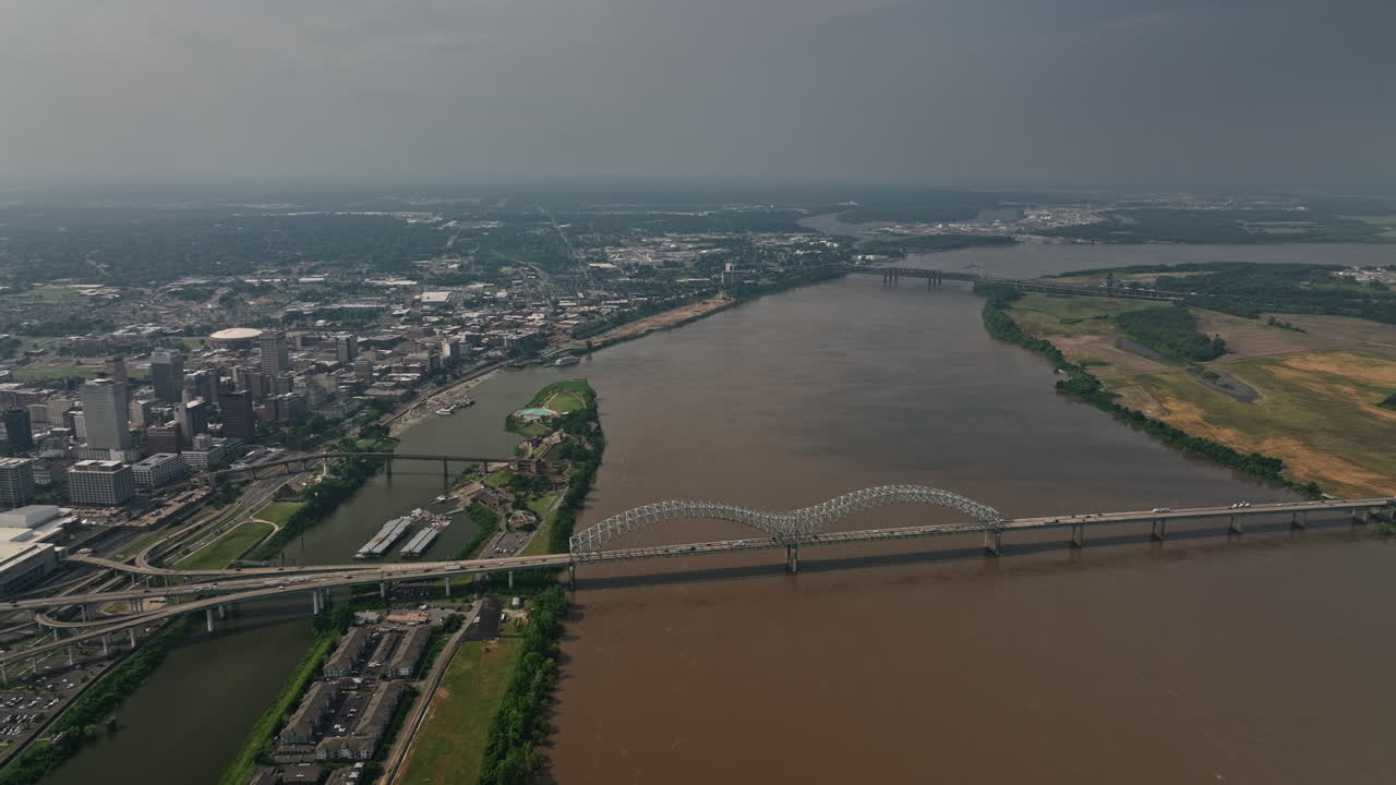 memphis tennessee antena v34 vista de ángulo alto sobrevuelo del río mississippi, panorámica desde arkansas hacia el centro de la ciudad capturando el puente hernando de soto y el paisaje urbano - filmado con cine mavic 3 - mayo de 2022
