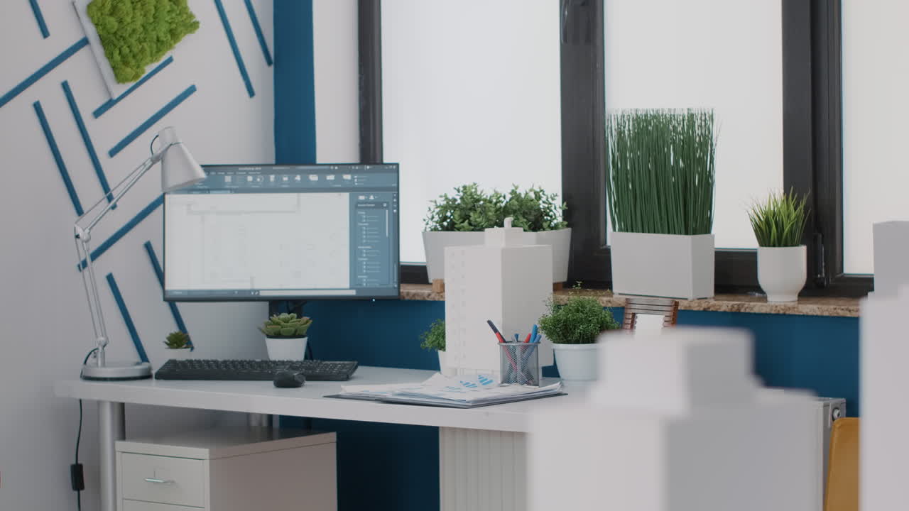 Office interior with desk, computer, and plants near window