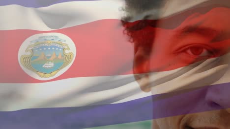 Animation-of-flag-of-costa-rica-over-african-american-man-at-beach