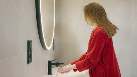woman washing hands in modern bathroom