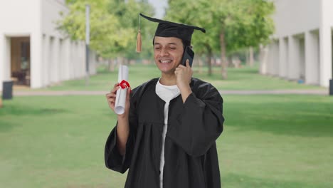 feliz universidad india hablando en la llamada después de la graduación