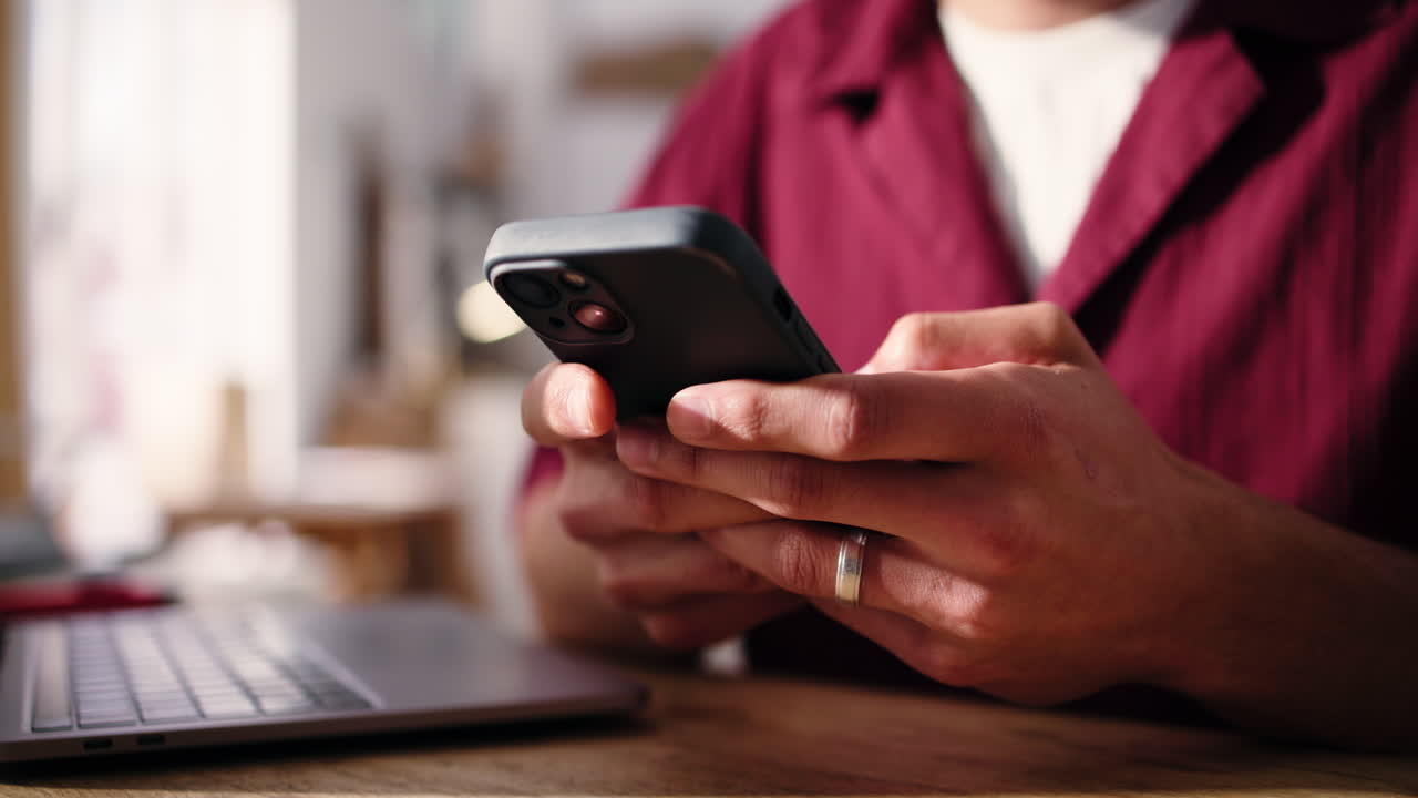 Nahaufnahme von Händen, die auf einem Smartphone tippen und scrollen