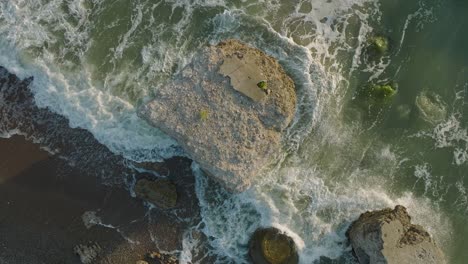 Beautiful-aerial-establishing-view-of-Karosta-concrete-coast-fortification-ruins,-sunny-summer-evening,-golden-hour-light,-stormy-waves-at-Baltic-sea,-ascending-slow-motion-drone-shot