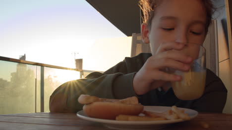 boy eating french fries with orange juice for breakfast