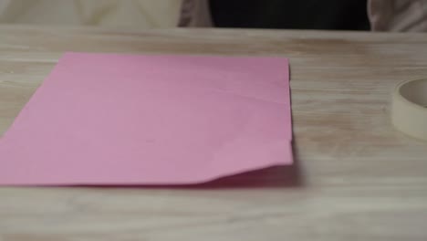 woman wrapping gift in pink paper