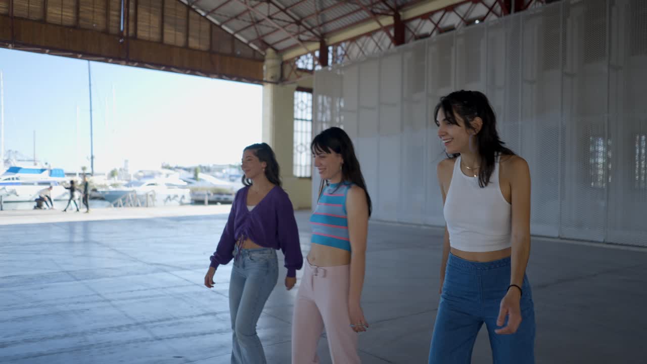 Three young women walking in a harbor