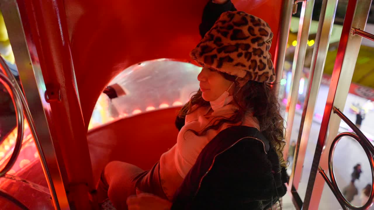 Woman enjoying a funfair ride at night