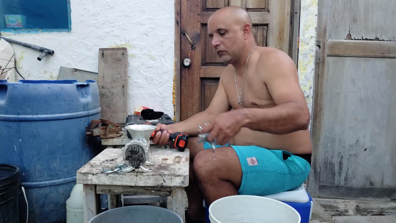 el hombre muele el pez cebo para hacer el pescado o los corta para el pescado más grande