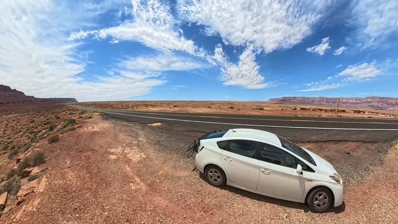 Time lapse of a Prius in front of a freeway in red rock desert of Arizona