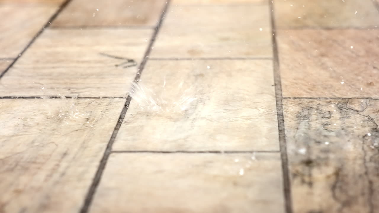 Slow motion regndråber falder på hvidlig-lyserød sten. Kamera 4K ved 240 FPS.