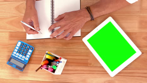 Close-up-view-of-desk-with-hands-writing