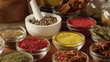 various spices in glass bowls close-up. middle eastern and arabian culture. seasoning and flavors. pepper, coriander, cinnamon, turmeric, paprika, cumin. different kinds of dry herbs for cooking.