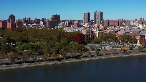 long drone follow of yellow school bus down the fdr drive along the harlem river in harlem, manhattan, nyc