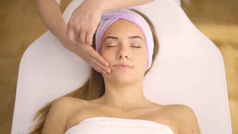 mulher recebendo uma massagem facial em um spa