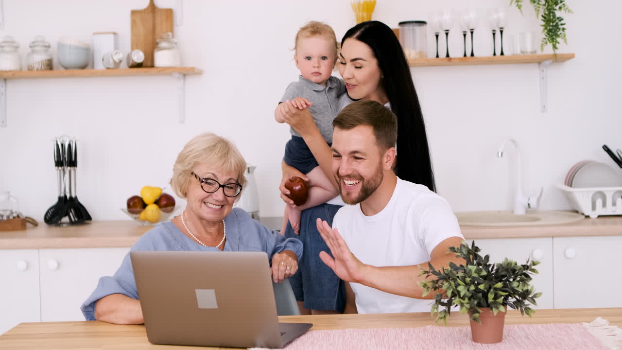 Happy Family Having A Video Call On Modern Laptop In Kitchen