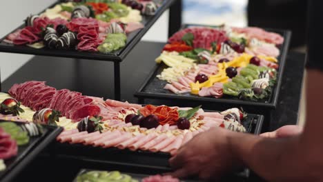 waiter places charcuterie board at a wedding or business banquet