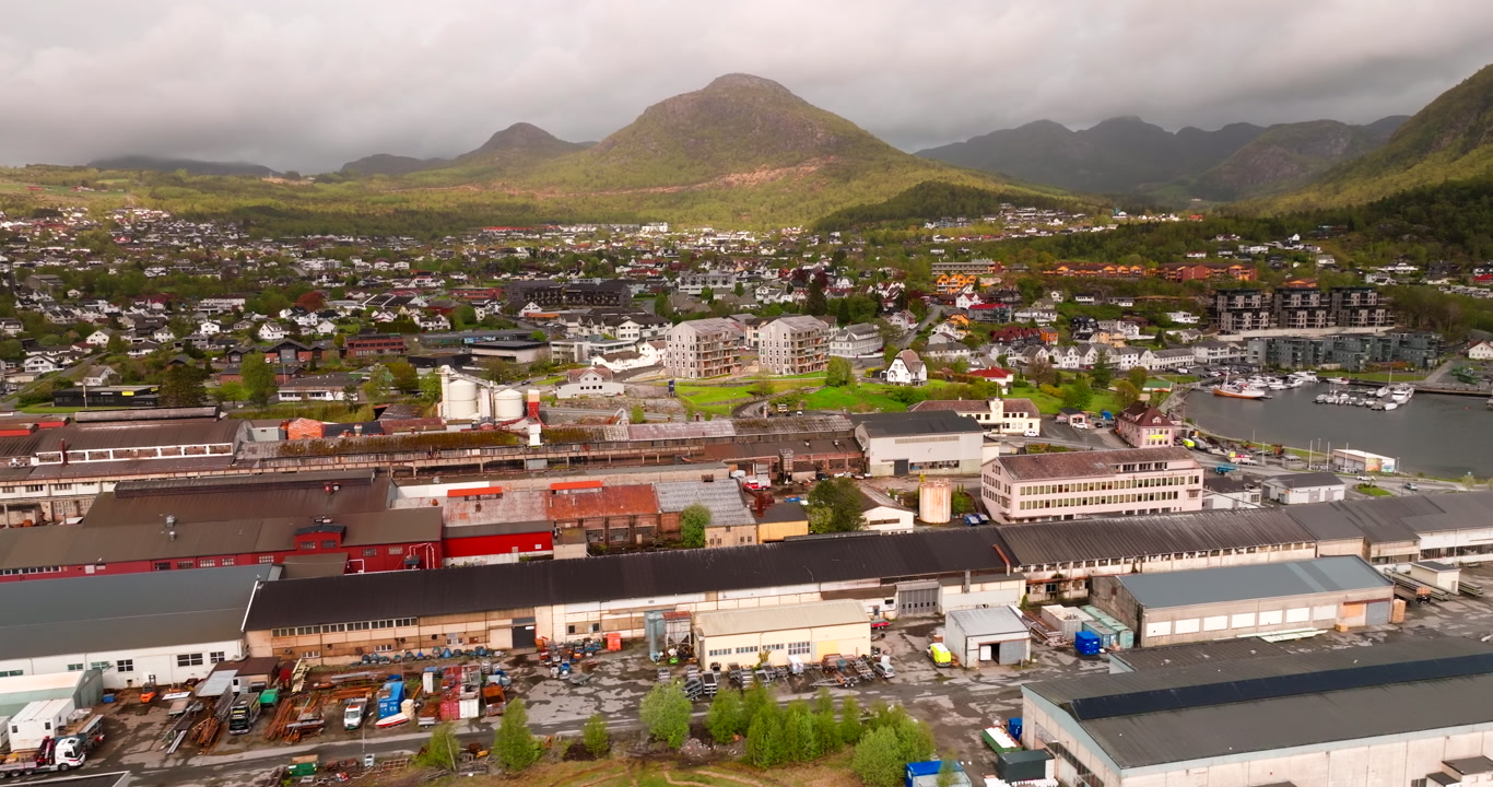 Jørpeland, Norway, showing the steel mill, surrounding residential areas, waterfront, and mountain backdrop in scenic Rogaland county