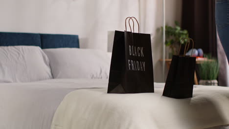 black friday shopping bags on a bed