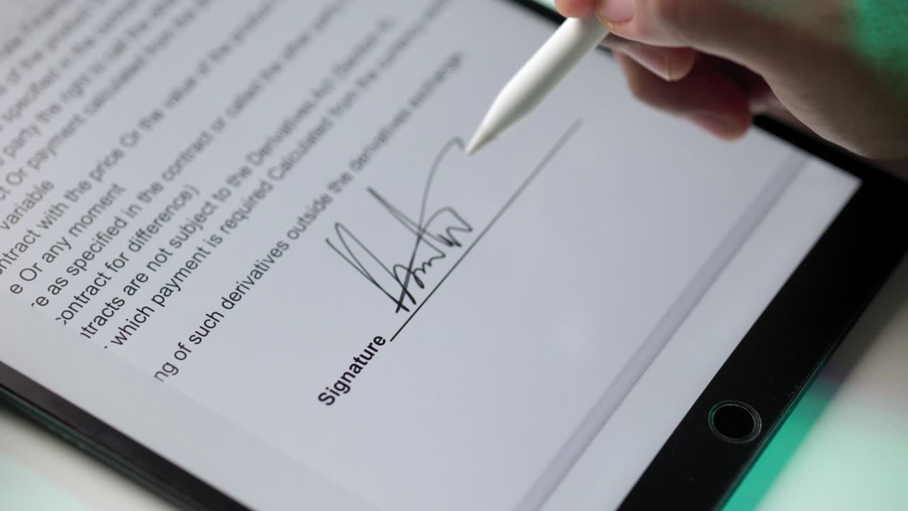 Electronic signature with green light. Businessman signing a business contract with stylus pen on tablet at night. Man signing contract on tablet at office. Business and technology concept.