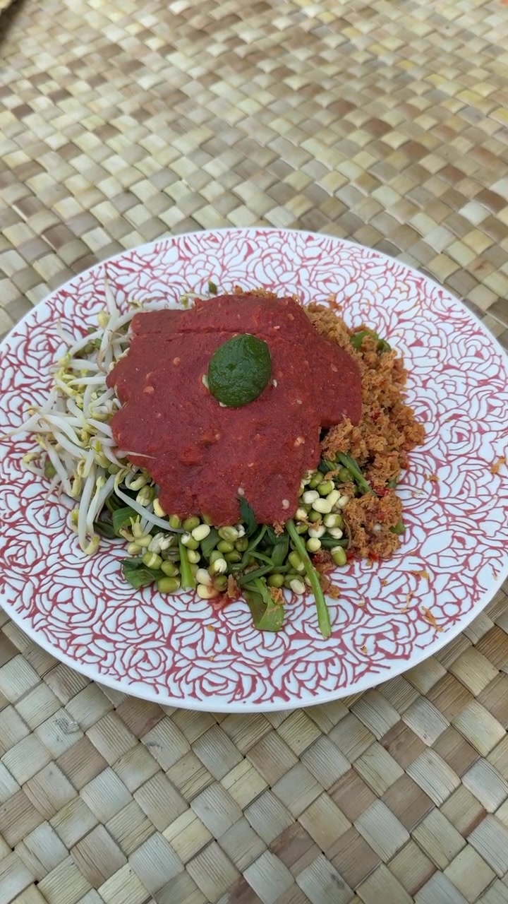 Insalata tradizionale indonesiana Urap Sayur servita su un piatto decorato.