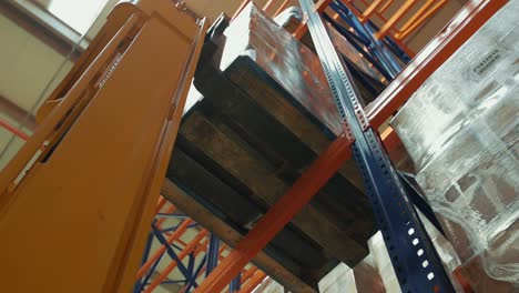 the fork lift picks up packages from the shelf in the warehouse