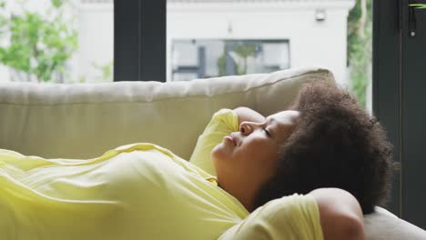 Video-of-plus-size-african-american-woman-relaxing-on-sofa