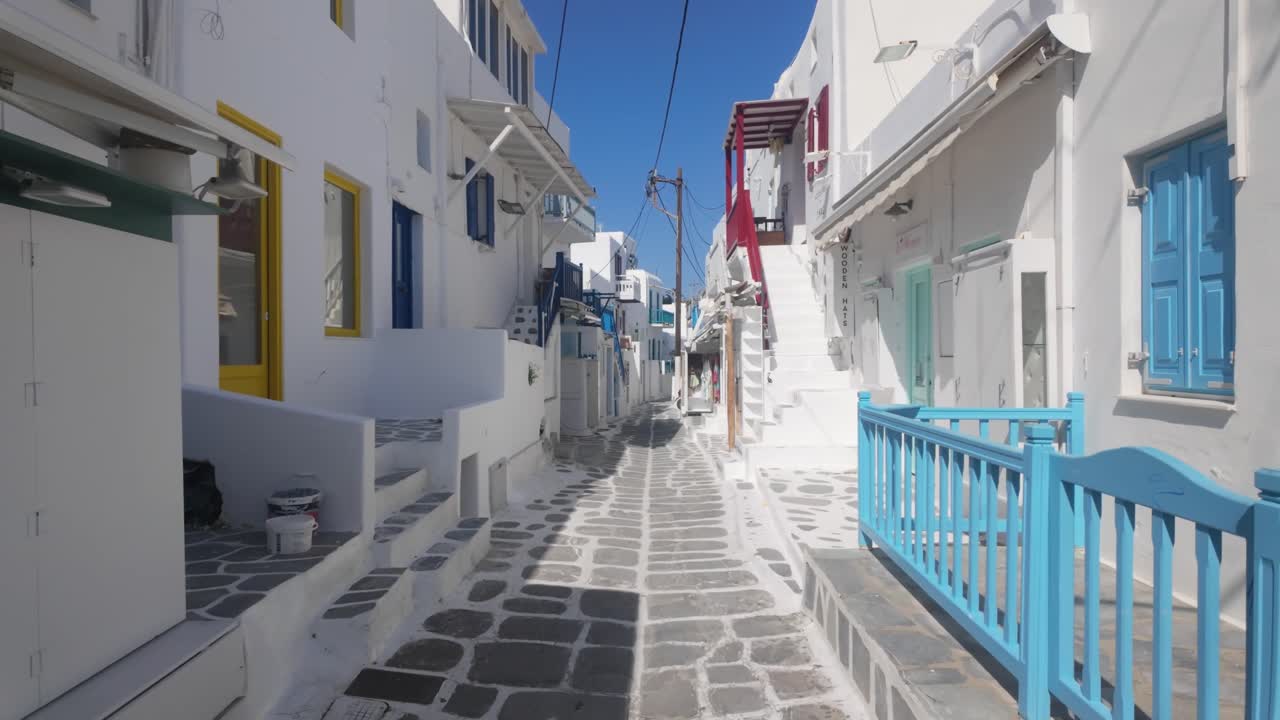 Walking through the famous traditional alleys of Mykonos, Greece, with whitewashed houses, blue details, and charming Cycladic architecture